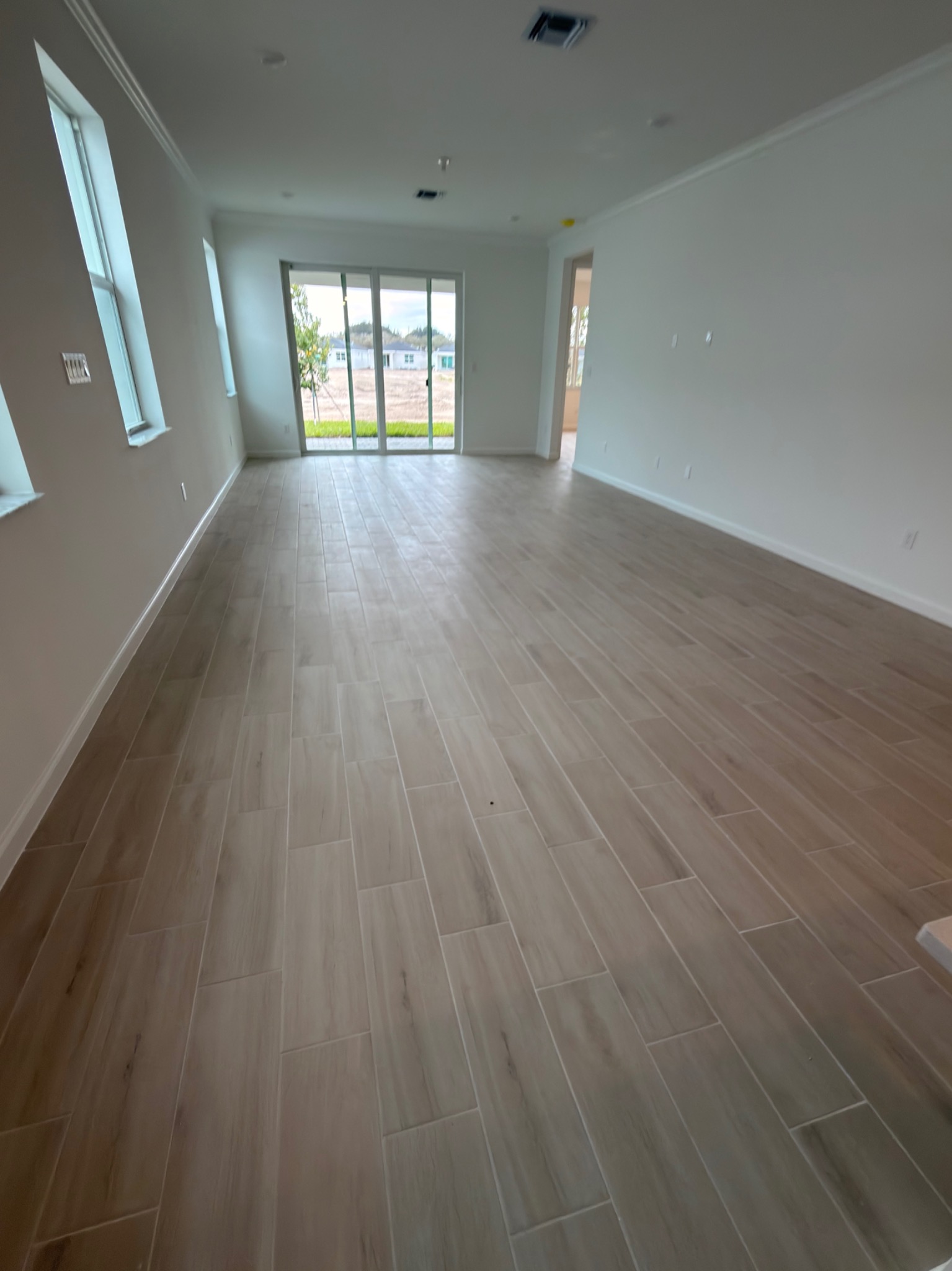Completed wood-look tile flooring in open living area
